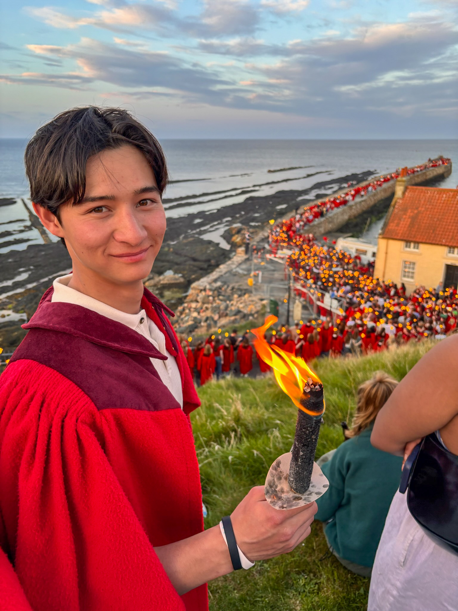 Alex in the University of St Andrews red gown during the May Dip torch procession